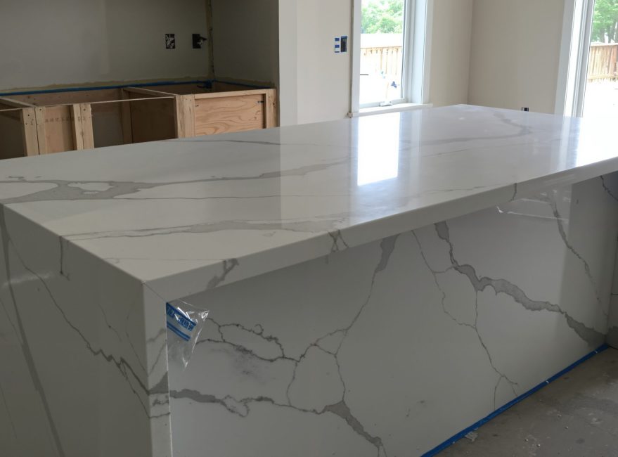 New Quartz Kitchen Island Countertop with Waterfall Edge in Home Under Construction. Modern Interior Design and Renovation Project.